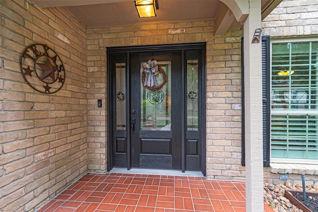 entrance to property featuring brick siding