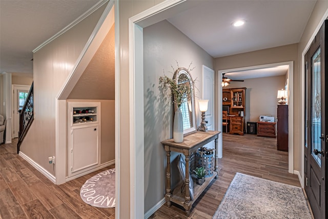 hallway with baseboards, stairs, and wood finished floors