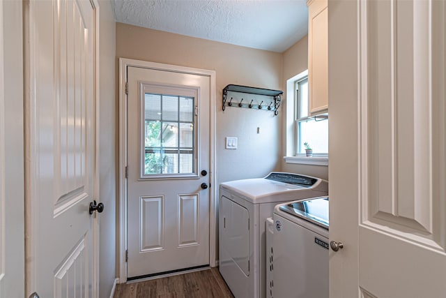 laundry room with laundry area, dark wood finished floors, a healthy amount of sunlight, and washing machine and clothes dryer