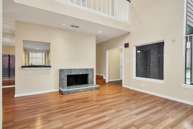 7447 Cambridge St, Houston, TX 77054 - unfurnished living room featuring a high end fireplace, wood finished floors, baseboards, and a high ceiling