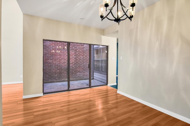 7447 Cambridge St, Houston, TX 77054 - spare room with wood finished floors, a chandelier, and baseboards