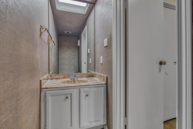 7447 Cambridge St, Houston, TX 77054 - bathroom with vanity, a skylight, and a textured ceiling