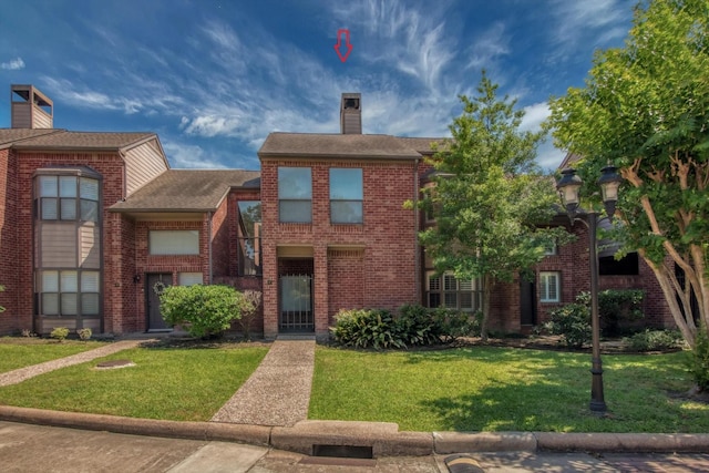 7447 Cambridge St, Houston, TX 77054 - view of front of home featuring a chimney, a front lawn, brick siding, and roof with shingles