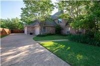 view of front of house with concrete driveway, a garage, and a front lawn