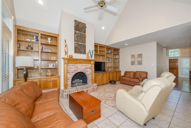 living room with a ceiling fan, a brick fireplace, light tile patterned flooring, and built in shelves