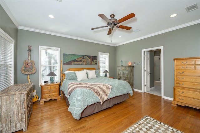 bedroom featuring crown molding, baseboards, wood finished floors, and visible vents
