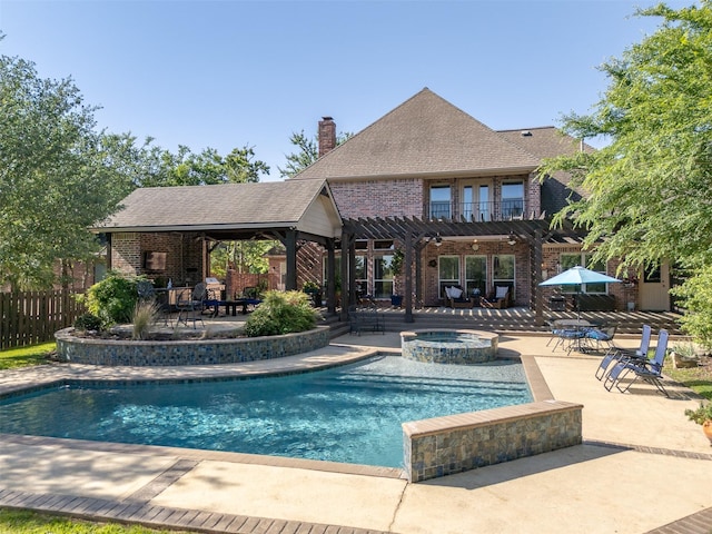 view of pool with a pergola, a pool with connected hot tub, fence, and a patio area