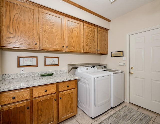 clothes washing area with cabinet space, independent washer and dryer, crown molding, and light tile patterned floors