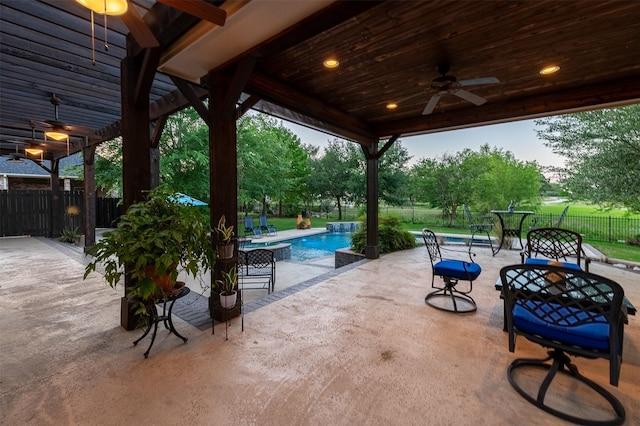 view of patio with fence, a ceiling fan, and a fenced in pool