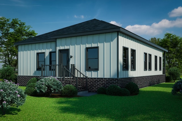 rear view of property with a lawn, board and batten siding, roof with shingles, and brick siding