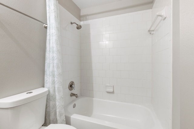 full bathroom featuring shower / tub combo with curtain, a textured wall, and toilet