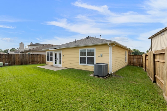rear view of property featuring a fenced backyard, french doors, central AC unit, a patio area, and a yard