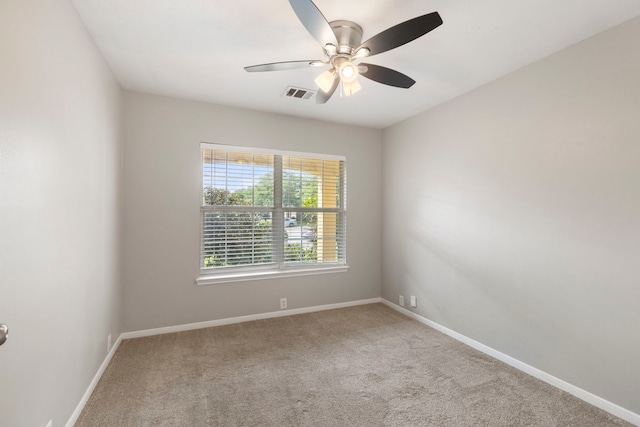 carpeted spare room with a ceiling fan, baseboards, and visible vents
