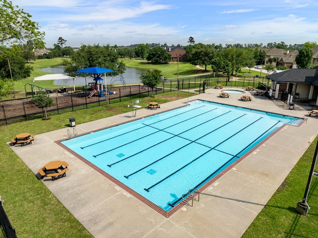 pool featuring a water view, a yard, and playground community
