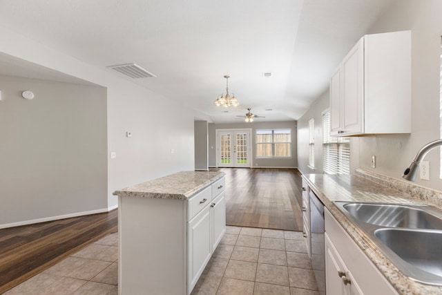 kitchen featuring a notable chandelier, a sink, dishwasher, a kitchen island, and visible vents