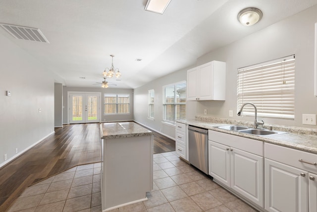 kitchen with visible vents, a kitchen island, a chandelier, a sink, and dishwasher