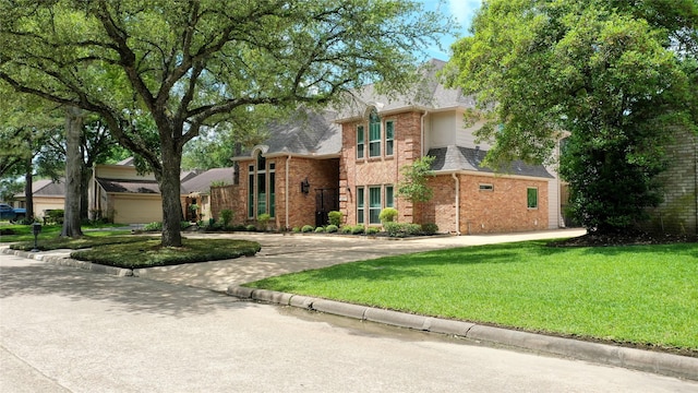 traditional-style house featuring brick siding, driveway, and a front lawn
