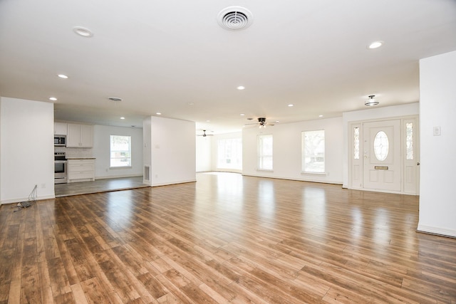 unfurnished living room featuring recessed lighting, baseboards, visible vents, and light wood-type flooring