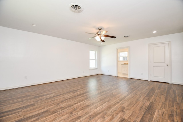 spare room featuring a ceiling fan, baseboards, visible vents, and wood finished floors
