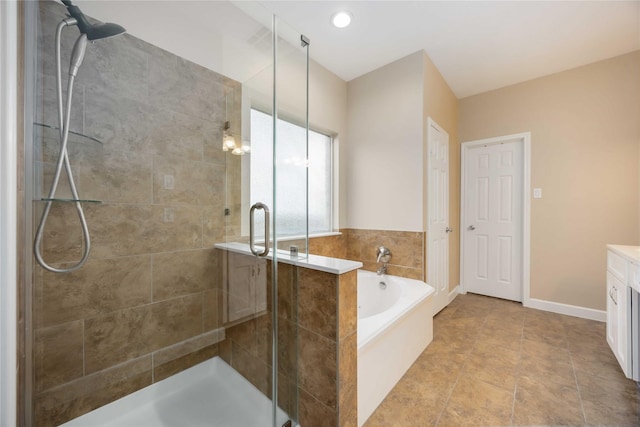 full bathroom featuring vanity, baseboards, a bath, and a stall shower