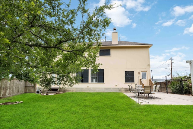 back of house with a fenced backyard, a yard, and a patio area