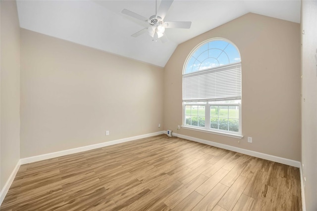 empty room with light wood-style floors, baseboards, ceiling fan, and vaulted ceiling