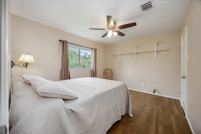 bedroom featuring baseboards, a ceiling fan, wood finished floors, and visible vents
