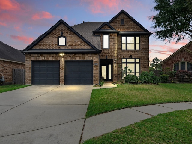 traditional-style home with a garage, a front yard, driveway, and brick siding