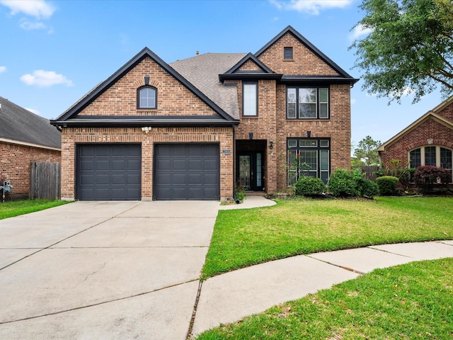 traditional-style house with brick siding, an attached garage, driveway, and a front yard