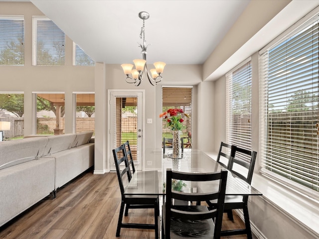 dining room featuring baseboards, a chandelier, a healthy amount of sunlight, and wood finished floors