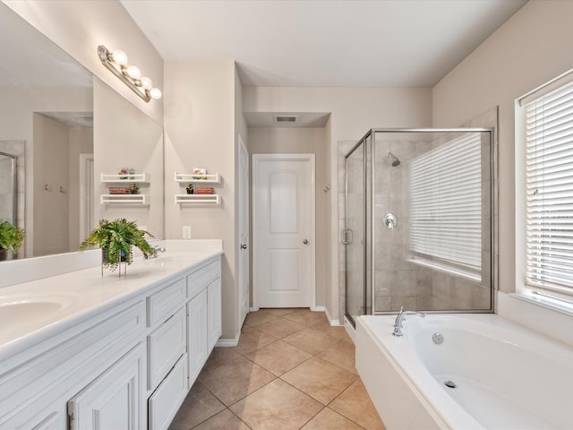 bathroom featuring a sink, double vanity, tile patterned floors, a bath, and a stall shower