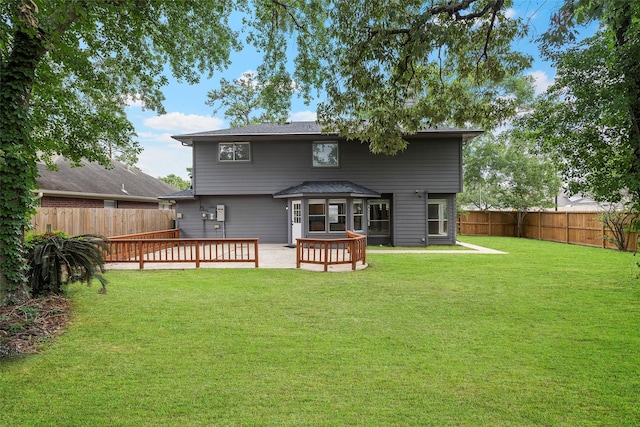 back of house featuring a lawn and a fenced backyard