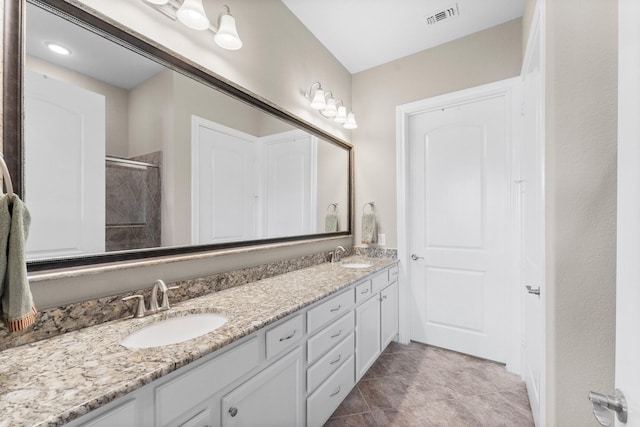full bath with visible vents, a sink, a shower, and double vanity