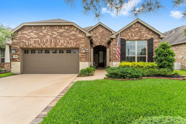 single story home featuring driveway, a front yard, brick siding, cooling unit, and an attached garage