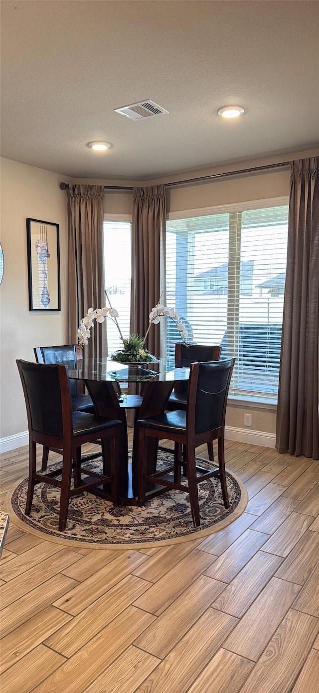 dining space with baseboards, recessed lighting, visible vents, and light wood-type flooring