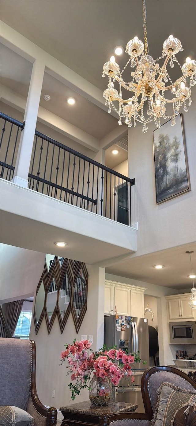 staircase with recessed lighting, a high ceiling, and an inviting chandelier