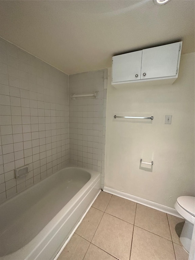 bathroom featuring tile patterned flooring, baseboards, and toilet