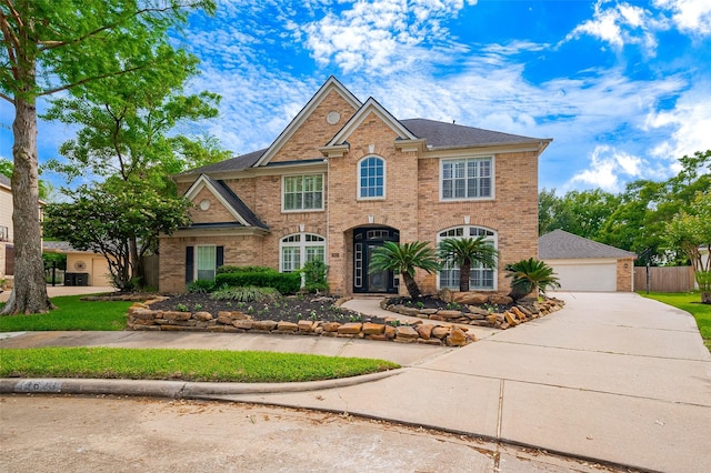 view of front of home with brick siding and a detached garage