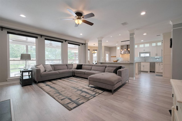 living area with ornate columns, ceiling fan, light wood-style flooring, recessed lighting, and ornamental molding