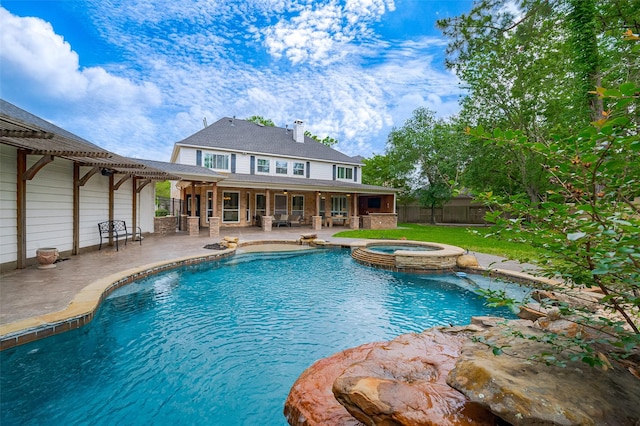 view of swimming pool with a patio area, fence, and a pool with connected hot tub