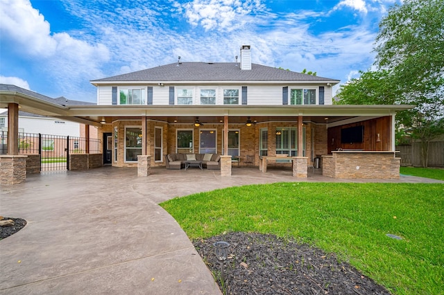 back of property with a ceiling fan, outdoor lounge area, a patio, and a chimney