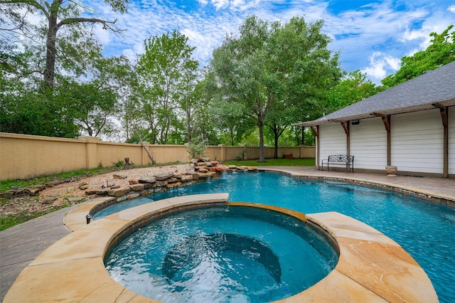 view of swimming pool with a fenced backyard and a pool with connected hot tub