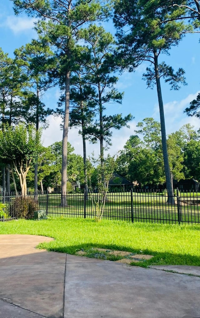 view of property's community with a lawn and fence
