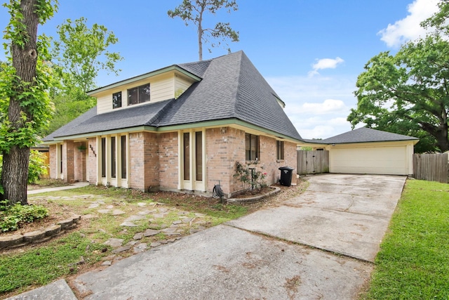 view of front of property featuring brick siding, fence, driveway, and a garage