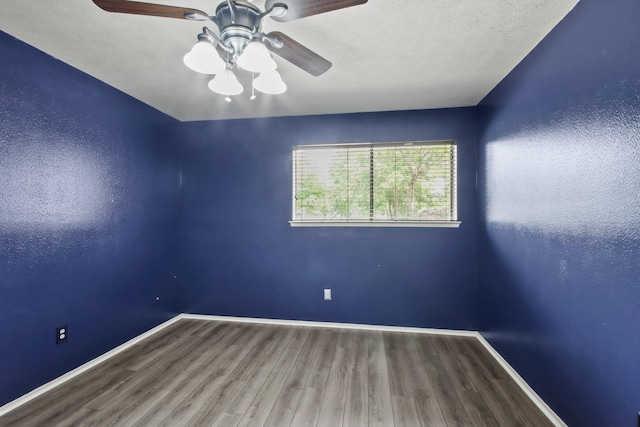 empty room with a ceiling fan, baseboards, and wood finished floors