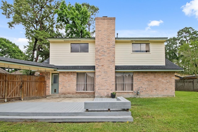rear view of property featuring a yard, fence, a chimney, and a wooden deck