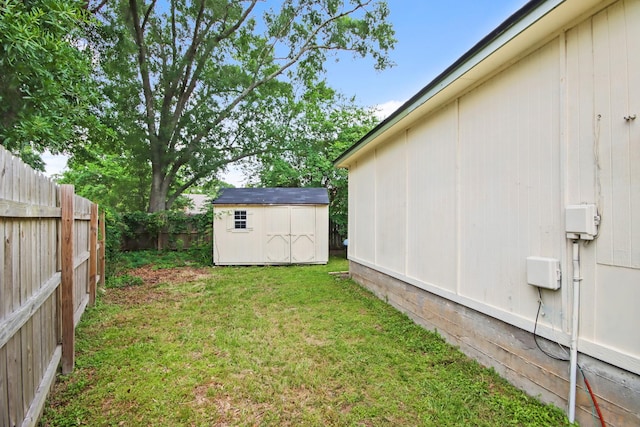 view of yard featuring a fenced backyard, an outdoor structure, and a shed