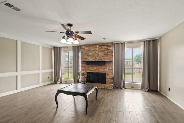 living area featuring visible vents, plenty of natural light, and wood finished floors
