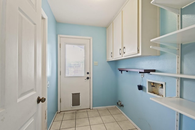 laundry room featuring cabinet space, light tile patterned floors, washer hookup, and baseboards