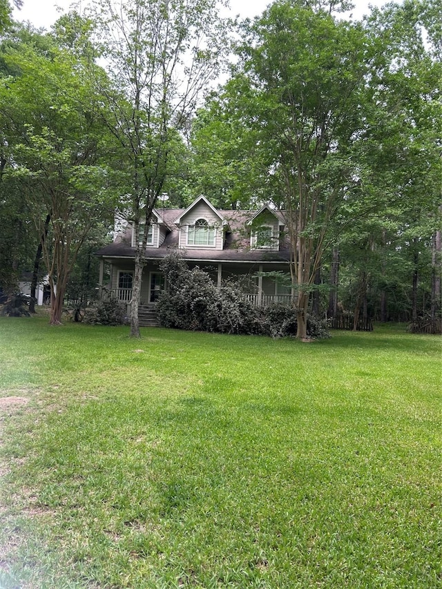 view of front of home with covered porch and a front lawn